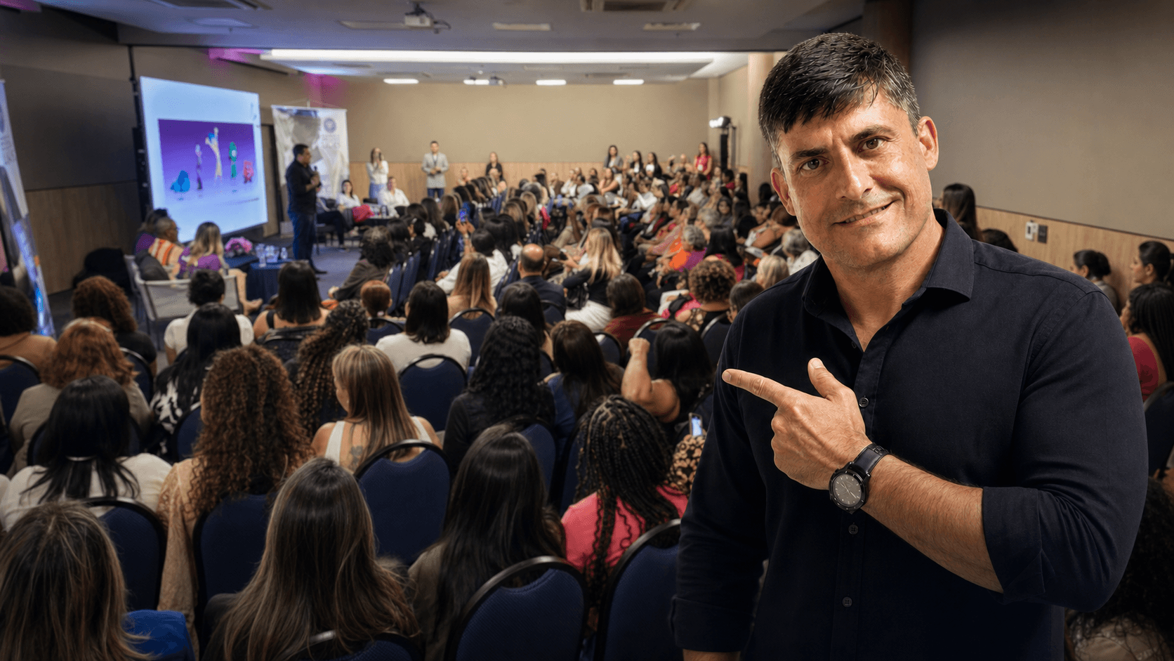 Antonio Carlos de Freitas apontando para uma palestra sua em auditório de empresa